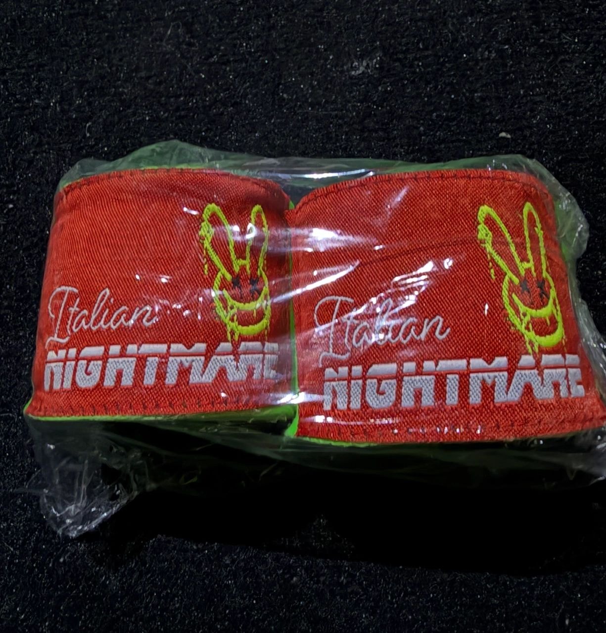 Custom Italian Nightmare hand wraps — red wristbands with embroidered logo, packaged in clear plastic